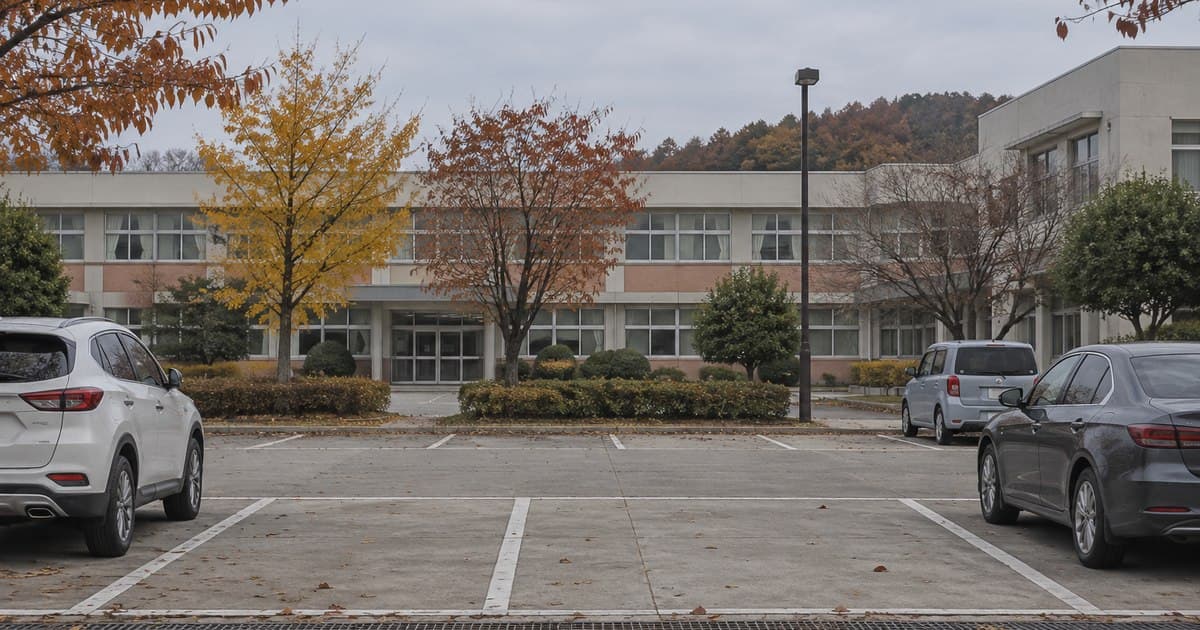 학교를 닮은 건물 앞 빈 주차면과 양쪽에 세워진 차량을 그린 AI 생성 이미지