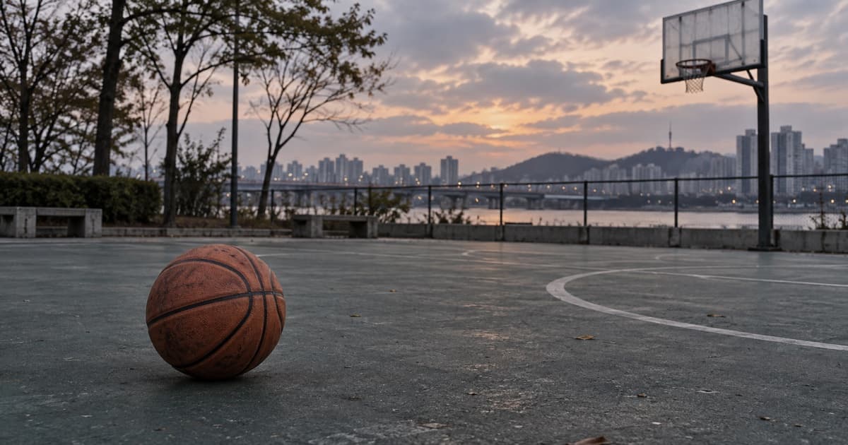 해 질 무렵 비어 있는 야외 농구 코트 바닥에 농구공 한 개가 놓여 있다. AI 생성 이미지